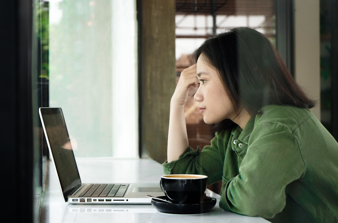 A_woman_using_a_laptop_to_streamline_contact_center_operations_through_knowledge_management_systems.jpeg